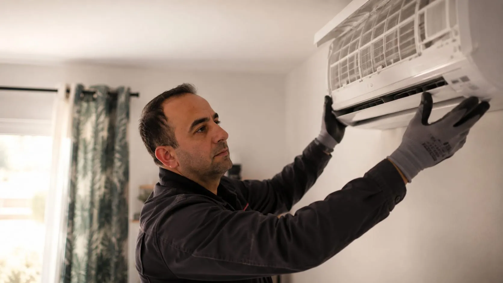 Installation d'une unité murale de climatisation par un technicien EDYCLIM